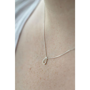 Drop shaped silver necklace by Marie Beatrice Gade shown on models neck