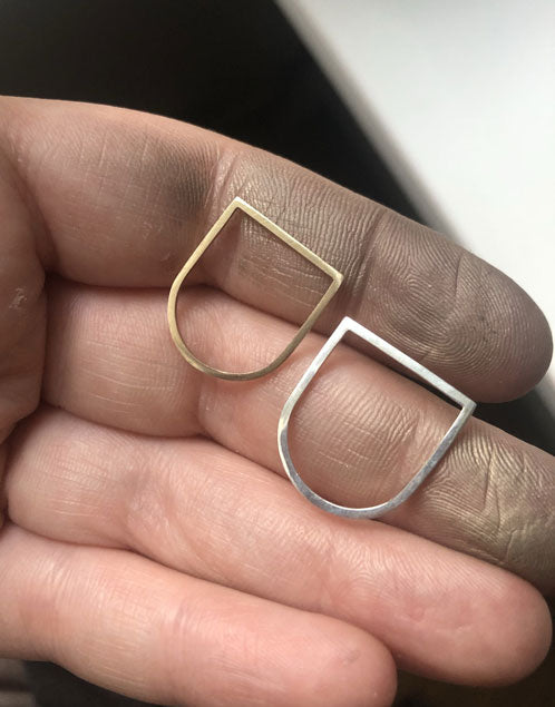 Alaska-u-shaped-rings-flat-top-gold-ring-and-flat-top-silver-ring-by-Marie-Beatrice-Gade-in-hand