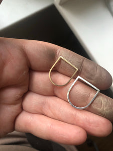 Alaska-u-shaped-rings-flat-top-gold-ring-and-flat-top-silver-ring-by-Marie-Beatrice-Gade-in-hand