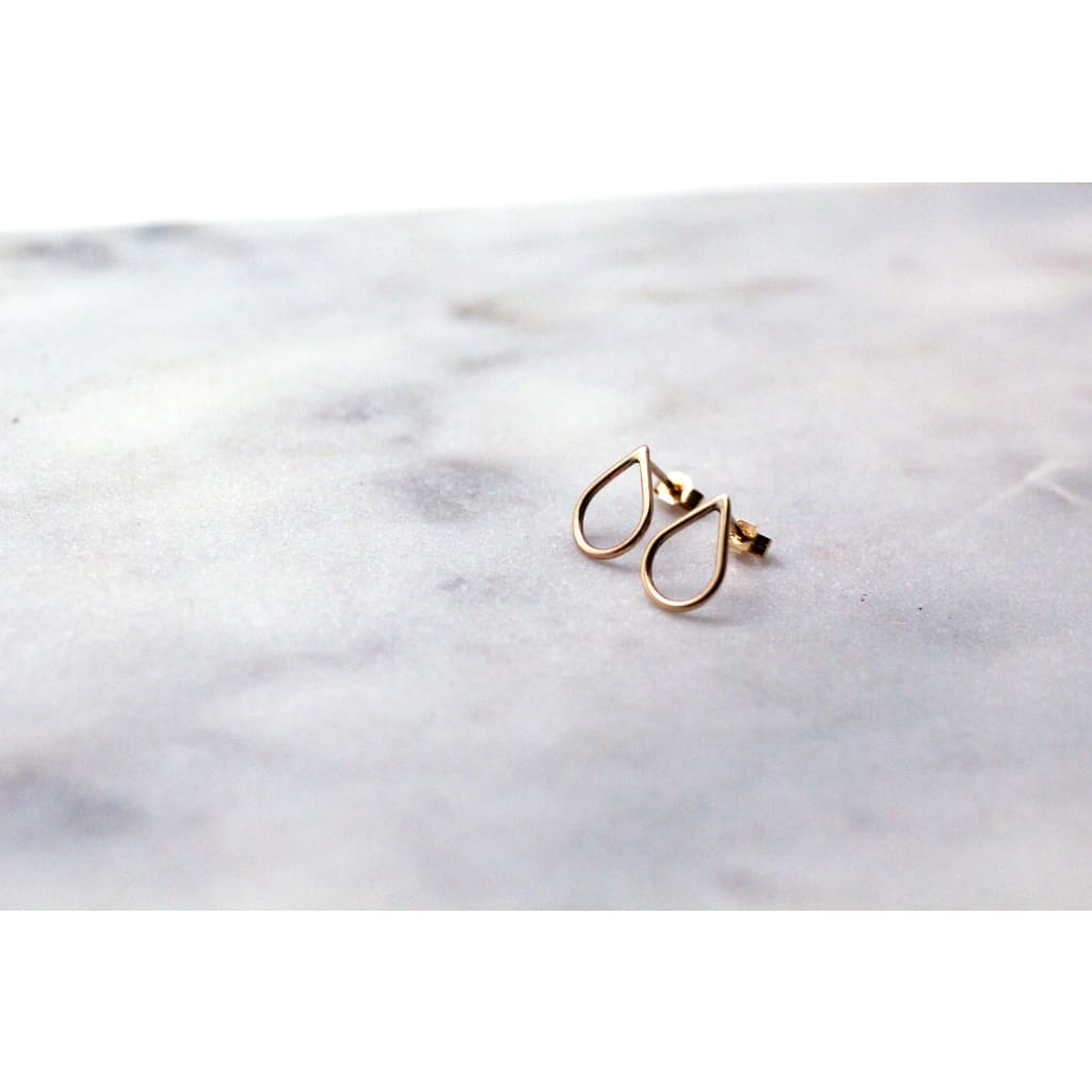 Recycled 9 ct yellow gold Filippa Mini earrings by eco jeweller M of Copenhagen laid out on marble