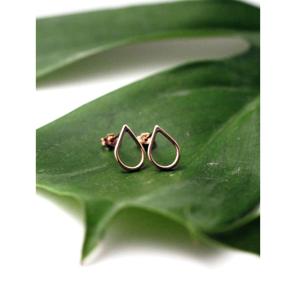 Artisan made Filippa 9ct yellow gold earrings by eco jeweller M of Copenhagen laid out on a leaf