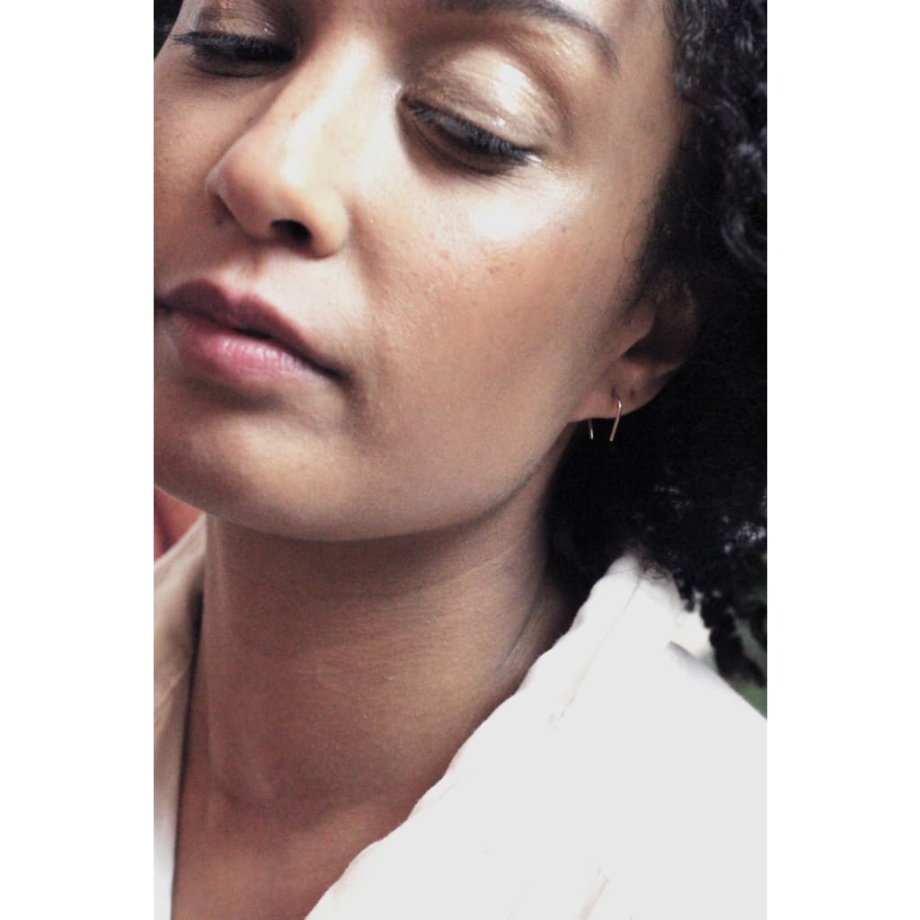 Artisan crafted Hook mini earrings from recycled gold by M of Copenhagen on model up close