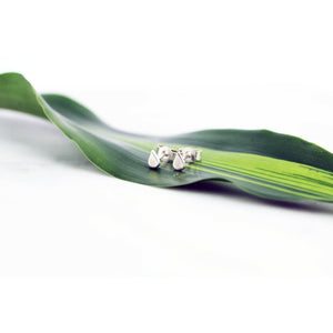 Laguna mini earrings by M of Copenhagen laying on a leaf